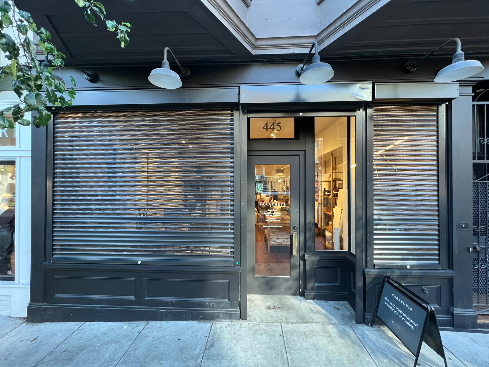 Perforated rolling security shutters protecting a San Francisco, California commercial storefront