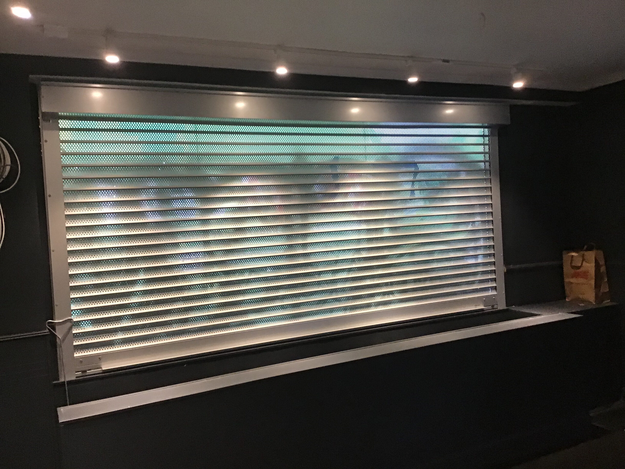 Interior perforated rolling security shutters installed at a San Francisco, California business